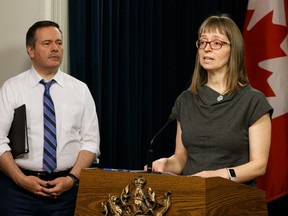 Premier Jason Kenney listens to Dr. Deena Hinshaw, Chief Medical Officer of Health, during a news conference about the COVID-19 pandemic at the Alberta Legislature in Edmonton, on Wednesday, March 25, 2020. Photo by Ian Kucerak/Postmedia