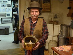 Kootenai Brown Pioneer Village's Farley Wuth shows off an antique spittoon, a remaining artifact from the reign of the King Edward Hotel. Photo by Riley Cassidy