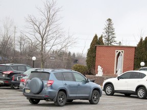 Participants stay in their vehicles to pray the rosary near a grotto honouring Our Lady of Fatima at Our Lady of Good Counsel Catholic Church on Tuesday. BRIAN KELLY