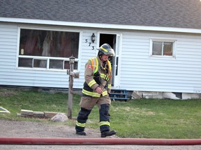 A firefighter walks past the scene of a house fire at 573 Black Rd., on Sault Ste. Marie, Ont., on Tuesday, May 5, 2020. (BRIAN KELLY/THE SAULT STAR/POSTMEDIA NETWORK)