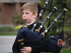 Benjamin Eddie, 9, plays the bagpipes outside his family home in Bright's Grove, in tribute to front-line workers. Paul Morden/Postmedia Network