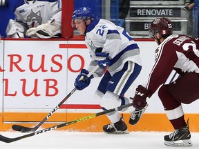 Sudbury Wolves defenceman Jack Thompson (22) plays the puck while under pressure from Peterborough Petes forward Chad Denault (22) during first-period OHL action at Sudbury Community Arena in Sudbury, Ontario on Friday, October 4, 2019.