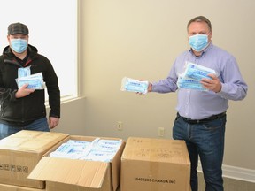 Stratford City Centre BIA chair Rob Russell and Stratford Mayor Dan Mathieson pose for a photo with a shipment of 18,000 face masks, earmarked for businesses in the city as they began to re-open last spring. (Galen Simmons/Beacon Herald file photo)