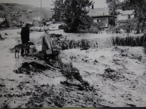 H.A. George, in overcoat, views devastation of raging Pat’s Creek on its flooding way to the Mighty Peace River near Riverfront Park.