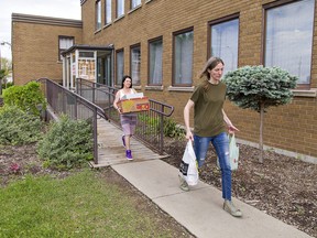Winter Warmth Emergency Shelter staff Andraya Goddard and Colleen Jones (right) carry food stocks out of the faciility at 180 Greenwich Street in Brantford, which wound up operations on Friday.