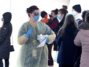 People were triaged as they waited at the Kingston COVID-19 assessment centre when it was set up in a tent along Brock Street just west of the Hotel Dieu Hospital main entrance. The centre was moved to the Memorial Centre not long afterward. (Ian MacAlpine/The Whig-Standard)