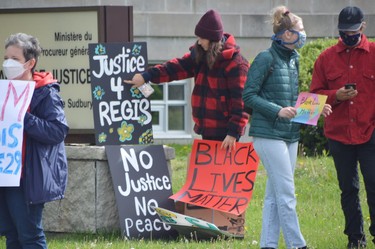 A demonstrator arranges signs outside the Sudbury Courthouse on Sunday. Those present raised concerns about the recent killing of George Floyd in Minneapolis, as well as the death of Regis Korchinski-Paquet, who fell from a 24th-floor balcony in Toronto on Wednesday.