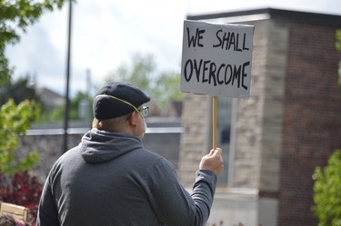 A sign quotes the famous civil rights anthem, also used in a speech by Martin Luther King, during a protest on Sunday regarding police brutality directed at people of colour.