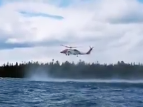 A coast guard helicopter comes to the aid of two kayakers who capsized in Lake Huron near Providence Bay.