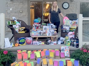 Exeter Community Scavenger Hunt organizer Amanda Overholt stands with the more than 150 gifts that were donated by local businesses and service groups for scavenger hunt participants. The popular event wrapped up last week.