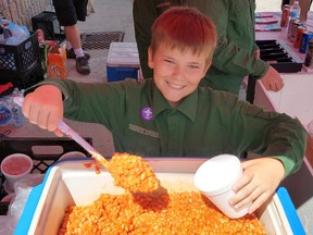 Cohen Henderson of Huron Park, a member of the 1st Zurich Scouts, scoops some beans at the 2019 Zurich Bean Festival. Organizers are taking the 2020 festival online due to COVID-19. Scott Nixon