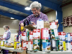 Bev Whitelaw boxes canned goods donated during the May 16 Miracle at Thames Campus Arena in Chatham. A similar project is planned for rural Lambton County in November.