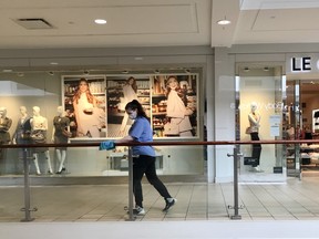 An employee at Peter Pond Mall wipes a railing  on Sunday, May 17, 2020. Vincent McDermott/Fort McMurray Today/Postmedia Network