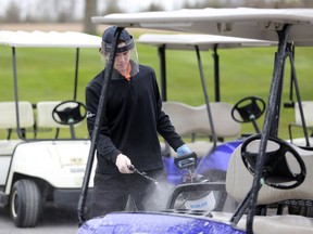 Amherstview Golf Club staff member Jacob Wilson disinfects a golf cart on May 16. Anyone who was at the golf course on June 22, 23 or 24 is required to be tested and self-isolate pending a negative test result. (Meghan Balogh/The Whig-Standard)