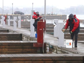 A pair of City of Kingston marina workers clean the docks at the Flora MacDonald Confederation Basin prior to the marina opening for the season. (Ian MacAlpine/The Whig-Standard)