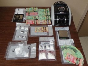 Kirkland Lake OPP show some of the cash, drugs and items seized after executing search warrants at locations in Larder Lake and Virginiatown.