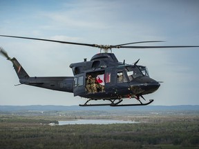 Master Cpl. Steve Wilson is photographed while he himself is taking photographs out the open door of a CH-146 Griffon helicopter during the, May 19 thank-you flyby over Pembroke. Cpl. Alex Heagle