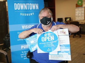 Brian Kuczma, program co-ordinator for Downtown Sudbury, shows off COVID-19 related items that will be given to Downtown Sudbury BIA businesses. The items, which are in limited supply, include face masks, capacity signage, welcome back posters, window clings and social distancing floor decals. Downtown stores interested in obtains the items can contact Downtown Sudbury.