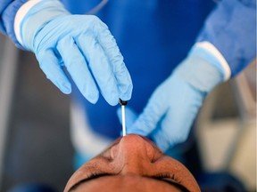 A health worker takes samples from a man to test him for COVID-19.