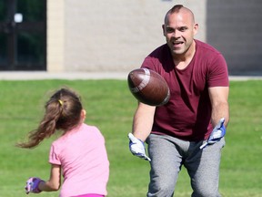 Bob Artelle plays catch with his six-year-old daughter, Kaleesy, at Ursuline College Chatham on Monday. Mark Malone/Postmedia Network