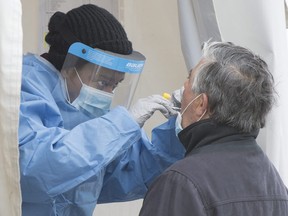 A health-care worker swabs a man at a walk-in COVID-19 test clinic in Montreal North, Sunday, May 10, 2020, as the COVID-19 pandemic continues in Canada and around the world.