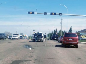 Residents appear to be filling potholes on the highway in Stony Plain.