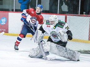 Elliot Lake Wildcats goaltender Jonathan Lemaire gets ready for a shot while Rayside-Balfour Canadians forward Matt Belanger looks for a possible redirect during NOJHL action this past season.