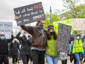 Isaac Bryant (left) and Shelby Bartsch (right) embrace as they lead a parade of over 1,000 protesters through the streets of downtown Grande Prairie, June 6, 2020.
