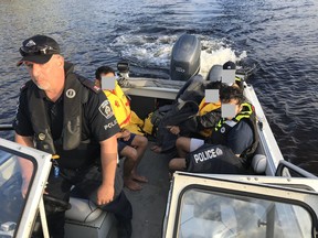 The marine unit of Greater Sudbury Police brings four youth back to shore after their inflatable boats were blown into the middle of Windy Lake on Saturday. GSPS PHOTO