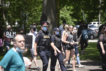 Woodstock police officers march with Black Lives Matter protesters in Victoria Park on Sunday. There was a small police presence in the park throughout the peaceful protest. (Kathleen Saylors/Woodstock-Sentinel-Review)