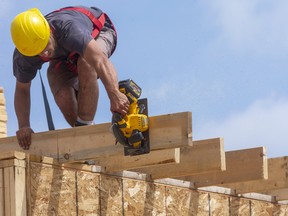 Vuk Cekic cuts the floor joists that will hold a cantilevered balcony on a new home being constructed north of Fanshawe Park Road in London. Mike Hensen/Postmedia Network