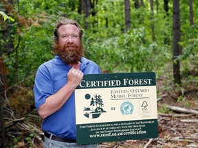 Quinte Conservation's Tim Trustham holds a new certification sign Thursday at Vanderwater Conservation Area  near Tweed. He says the recent Forest Stewardship Council of local managed forests ensures  responsible harvesting.