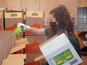 Volunteer Emily Radujko helps package boxes of food at Roy Bickell Public School in Grande Prairie, Alta. on Tuesday, June 16, 2020. The Grande Prairie Public School Division is distributing 220 boxes this week to its families in need during the COVID-19 pandemic.