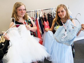 Sisters Faith (left) and Emma Vandermeer show two of the many prom dresses available at FreeHelpCK in Chatham. Mark Malone/Postmedia Network