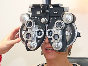 Nickel Belt MPP France Gelinas is shown the workings of refraction equipment at a Sudbury optometry clinic in this file photo. John Lappa/Postmedia Network