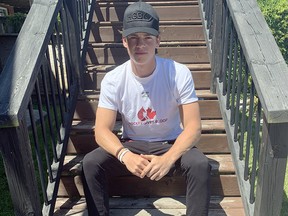 Sudbury Wolves defenceman Jack Thompson tries on his Hockey Gives Blood swag. Thompson recently joined the program as a player ambassador.