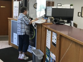 An unidentified woman receives help at the Service Ontario office inside the West Elgin municipal office. The municipality reopened the office on June 15 after a three-month closure due to COVID-19. Staff report a steady stream of customers during regular hours. Only one person is allowed indoors at a time to register vehicles, renew driver’s licenses, purchase plate stickers and update Ontario Health Insurance Program cards. Handout