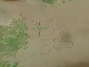 A Sudbury woman stranded on a canoe trip on the Spanish River created this SOS sign in the sand. SCREEN SHOT FROM OPP VIDEO, TAKEN FROM HELICOPTER