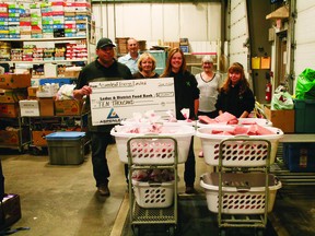 Shawn Ryan of Aspenleaf Energy (left) stopped by the Leduc & District Food Bank on June 19 to drop off a donation of meat and $10,000. Rebekah and Laura Knull of the Leduc 4-H Club (front row, l-r) also came by to be a part of the event. (Alex Boates)