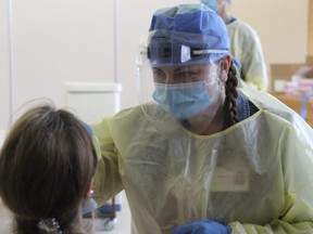 Kellie Ross, a Registered Practical Nurse at Cassellholme Home for the Aged performs a COVID-19 test swab on a staff member Friday. The hospital's outreach team is testing staff at long-term care and retirement homes twice a month.