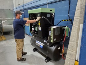 Damien Hobson, Mechanical Technician at ANCAM, is checking over a compressor after power has been turned back on, as part of re-opening the NWMO’s proof-test facility in Oakville.