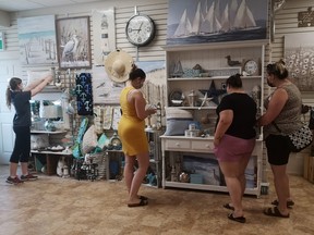 Jacqueline and Justine Cvetas with Jessica Longboat take a look at the new Pharmasave gift shop items while store employee Abigail Wellstead puts the final touches together.