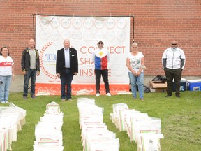 Filipino Champions of Canada (TFCC) contact lead Libby Bacon (from left to right), Town of Pincher Creek Councillor Scott Korbett, Mayor Don Anderberg, TFCC President Jerry Caingcoy, M.D. of Pincher Creek Councillor Bev Everts, and TFCC Vice President Abel Bagaling stand among the bags of rice which TFCC brought as part of the YYC Pinoy Cares community outreach. The bags were distributed to families within Crowsnest Pass, Pincher Creek, and Fort MacLeod.