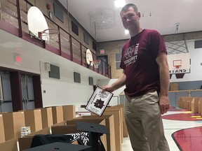 Wallaceburg District Secondary School tech teacher, Tim Dolbear, helps fill individualized graduation packages at the school on June 23. The packs are being delivered prior to the virtual graduation ceremony, which was scheduled for June 25.)