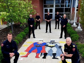 Firefighters pose in front of a mural created to thank the tireless work of essential workers. Photo provided by AIR 106.1
