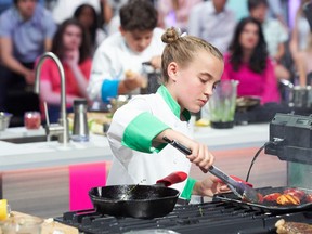 Audrey MacKinnon, the 12-year-old finalist from Brantford on Junior Chef Showdown, is shown here flipping food on a hot griddle as she battles another challenge with her co-competitors.