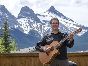 Canmore guitarist Andrew Ibanez plays in front of the Three Sisters Mountains. photo by Pam Doyle/www.pamdoylephoto.com