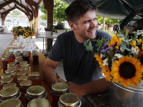 Mitchell Bateman sells flowers and honey at the Belleville Farmers' Market in 2018. The market is reopening Saturday for the first time since the coronavirus pandemic shut down much of Ontario.