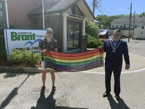 Jake Cerson (left), a Brant County employee, and Brant Mayor David Bailey hold a Pride scarf created by former local resident Shayne Newkirk, who now lives in Vittoria in Norfolk County. Newkirk delivered the scarf to Bailey in time for Monday's ceremony.