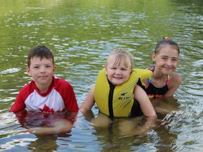 Nine-year-old Haven Schriner, McKenna Berichon, 5, and Skyleah Schriner, 11, of Brantford, cool off from the heat of the first official day of summer on Saturday. MICHELLE RUBY PHOTO